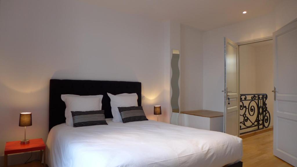 a bedroom with a large white bed with two pillows at Les Versaillaises B&B in Versailles