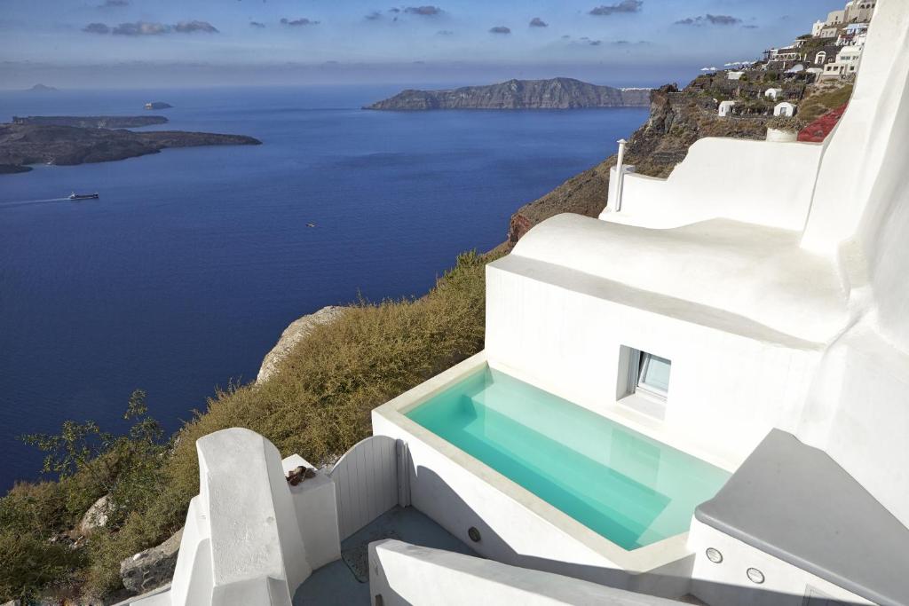 a view of the ocean from the side of a white building at Gaia Villa in Imerovigli