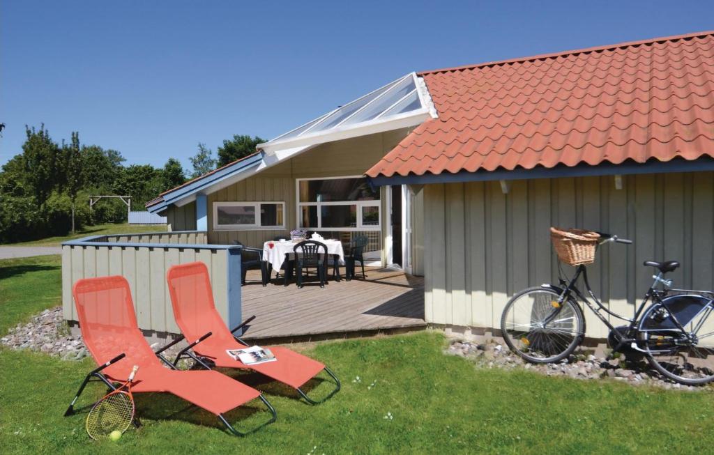 twee stoelen en een fiets naast een huis bij Kranich Ferienhäuser mit Innenpool in Hohendorf