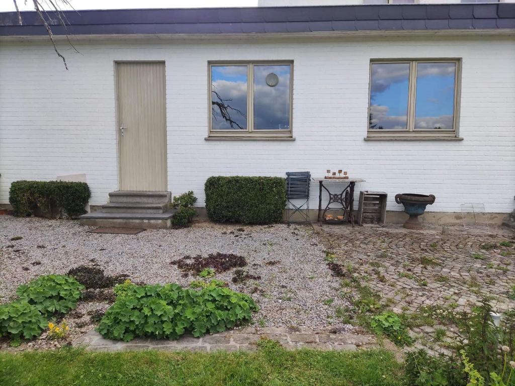 Una casa blanca con una mesa delante de ella. en Voitures et nature, en Stavelot