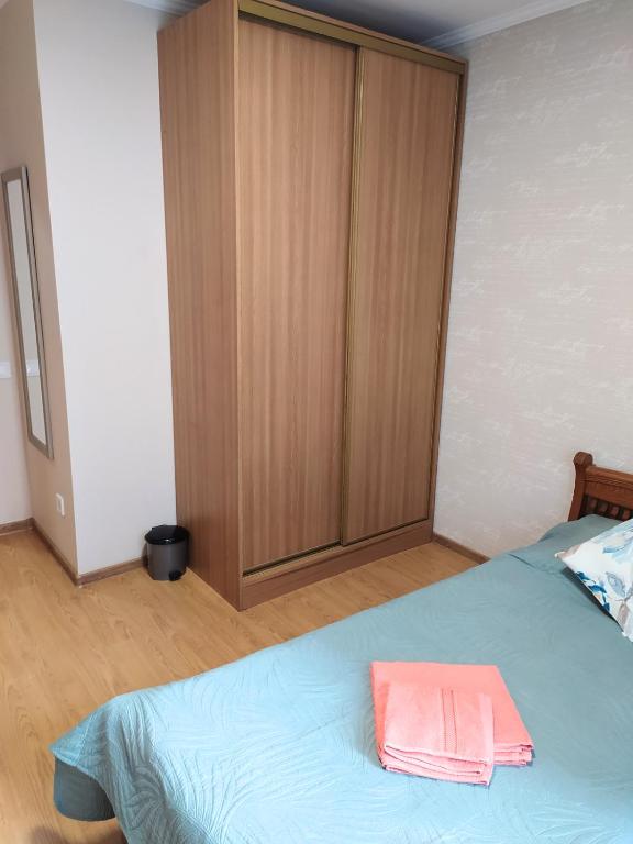 a bedroom with a bed with a wooden cabinet at Hotel Trias in Kyiv