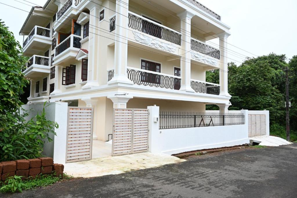 un edificio de apartamentos blanco con balcón en Visao en Old Goa