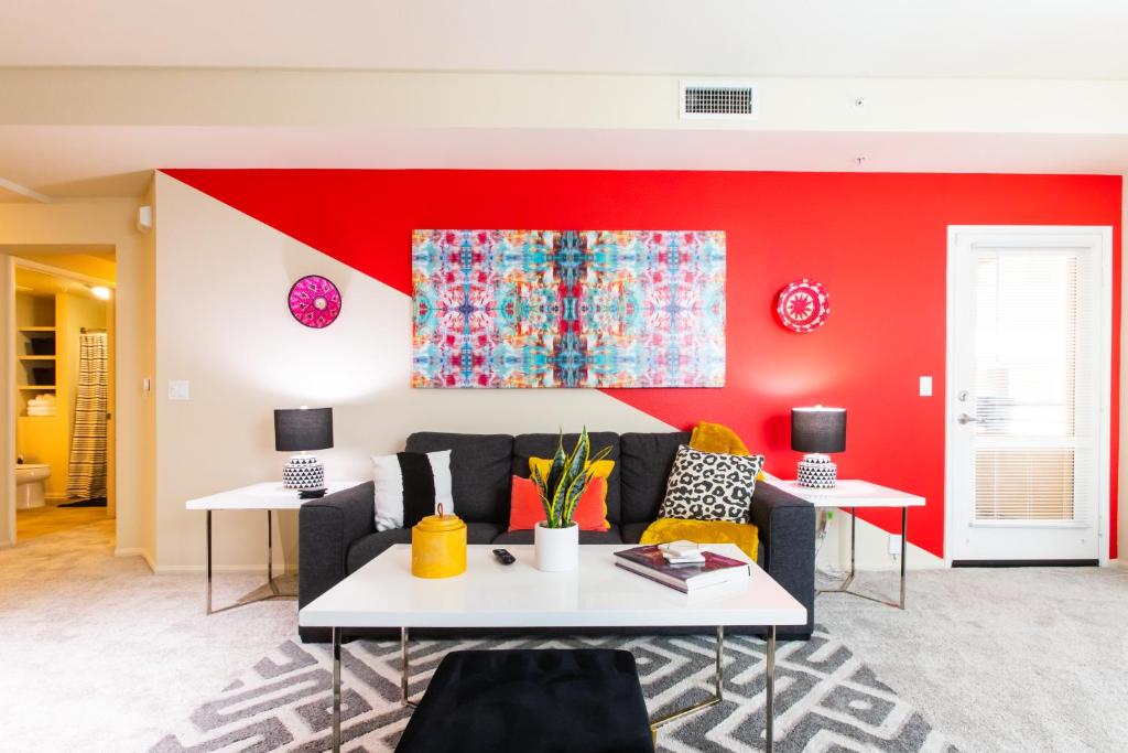 een woonkamer met een bank en een rode muur bij Continuum Homes - Irvine Apartments in Irvine