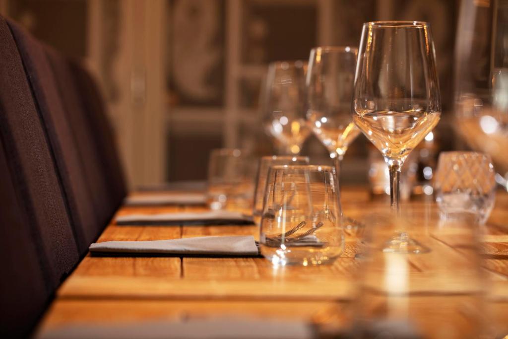 a wooden table with wine glasses on it at The Victoria Hotel in Bamburgh
