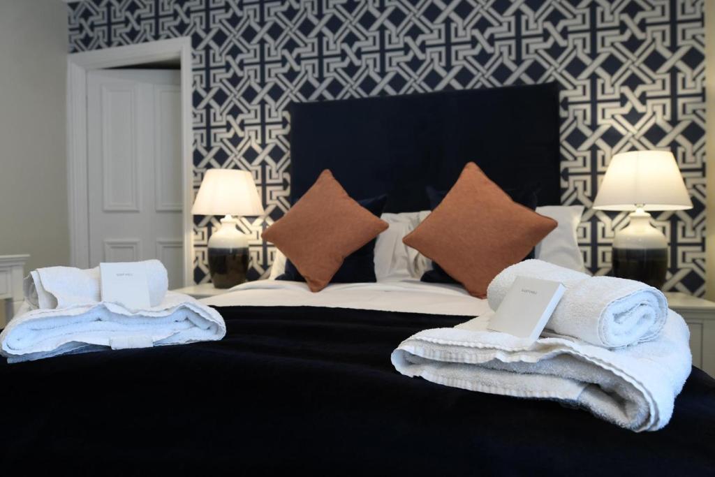 a bedroom with a large bed with towels on it at The Victoria Hotel in Bamburgh