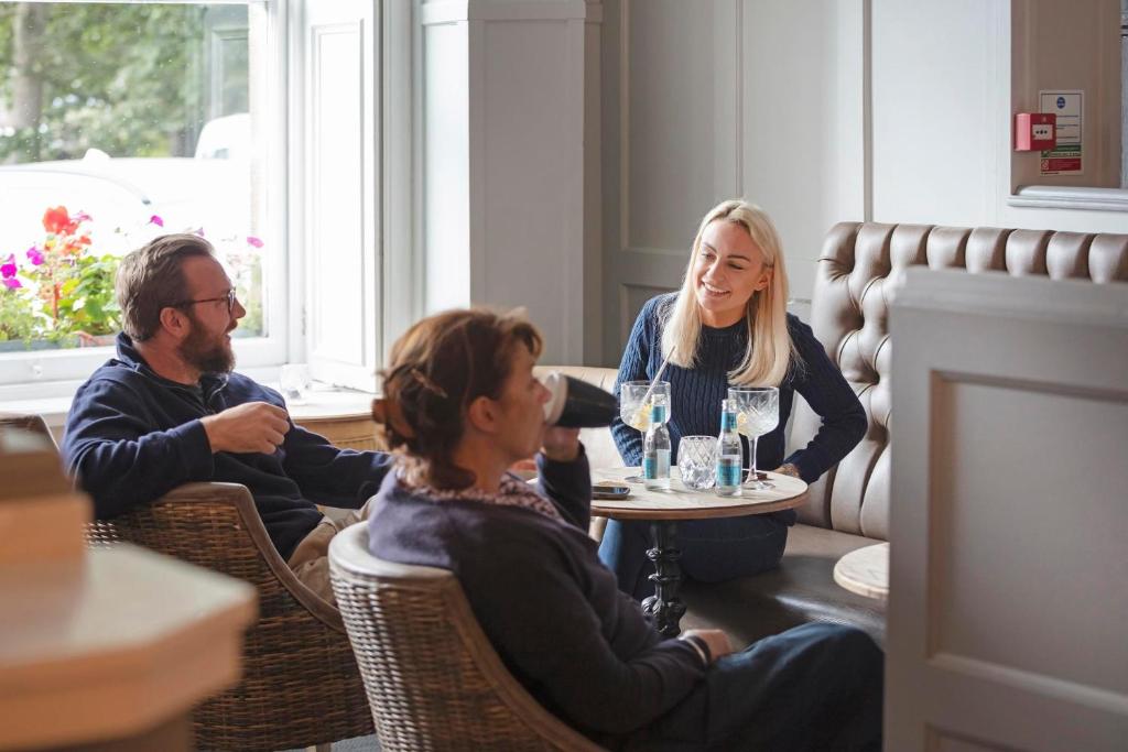 a group of people sitting at a table in a restaurant at The Victoria Hotel in Bamburgh