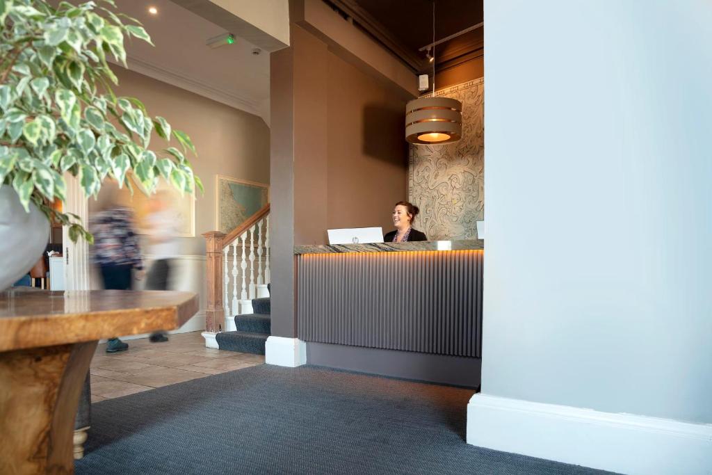 a woman sitting at a desk in an office at The Victoria Hotel in Bamburgh