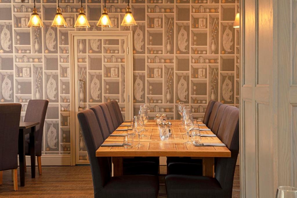 a dining room with a wooden table and chairs at The Victoria Hotel in Bamburgh