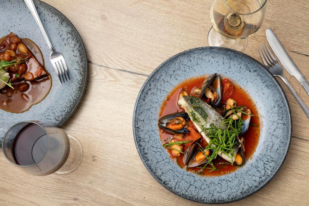 a table with two plates of soup with fish in it at The Victoria Hotel in Bamburgh