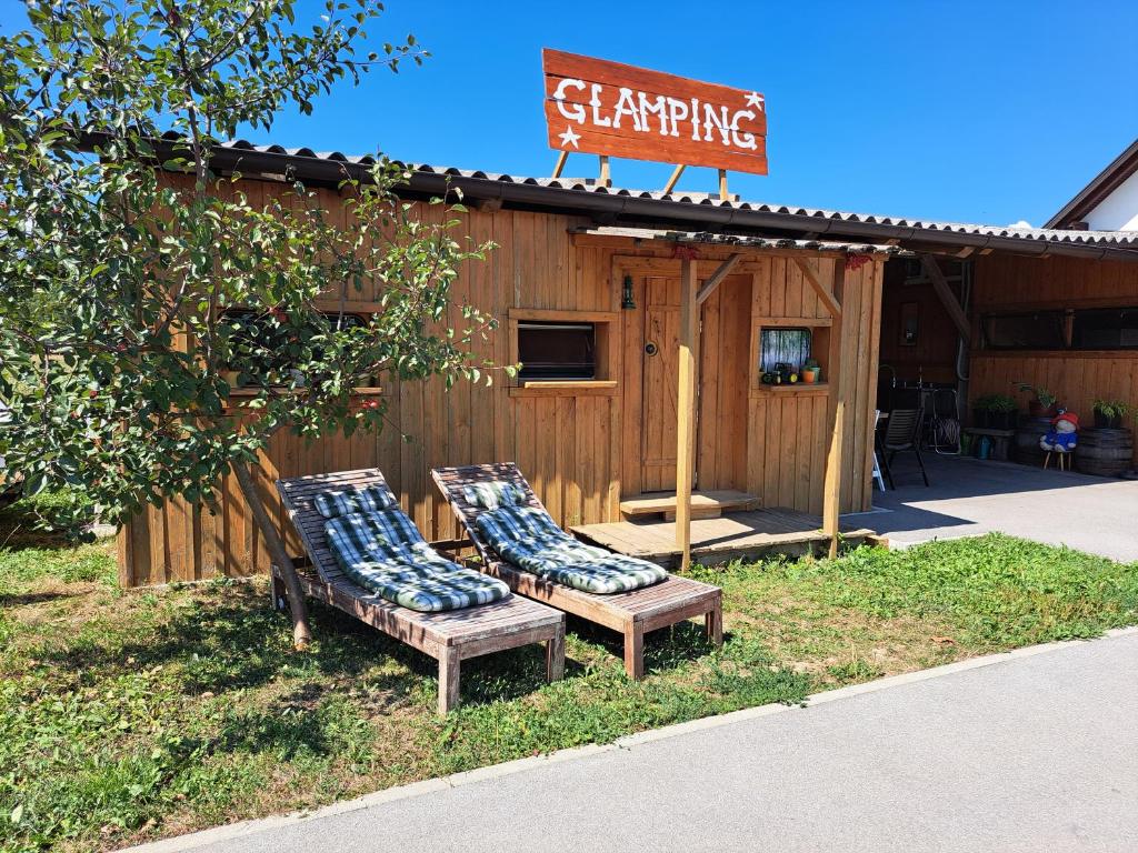 two benches with pillows sitting in front of a building at GLAMPING HOUSE RANČ LUŽE in Luže