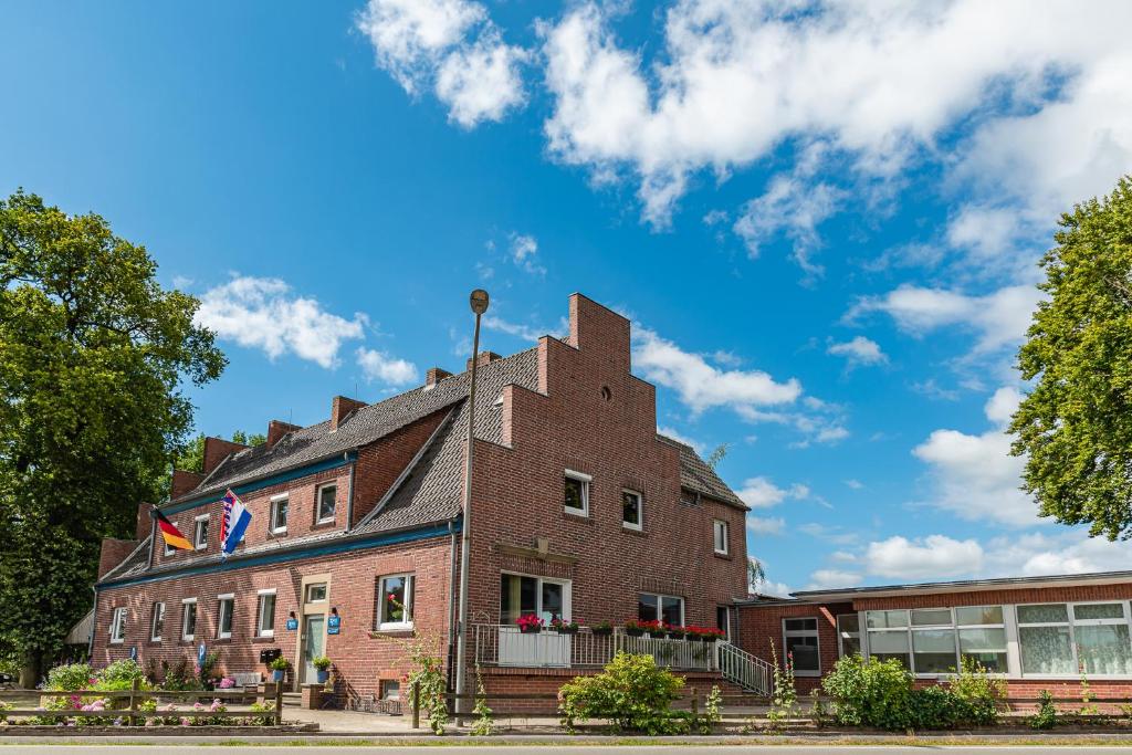 een bakstenen gebouw met twee vlaggen erop bij ZOLLHOES Zoek de grens op! in Barenfleer
