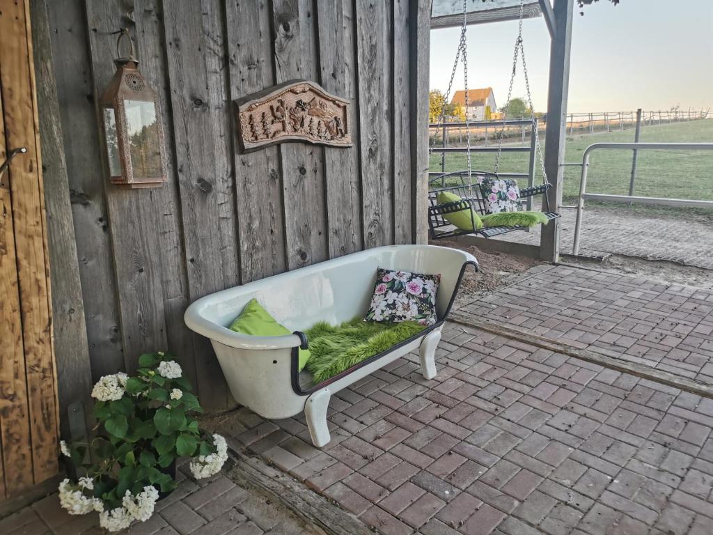 a bath tub sitting on a patio with a bench at Lavendelmond Glamping in Barntrup