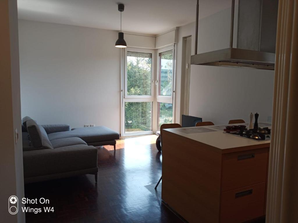 uma cozinha e sala de estar com um sofá e uma mesa em Appartamento DeLuxe con parcheggio gratuito em Segrate
