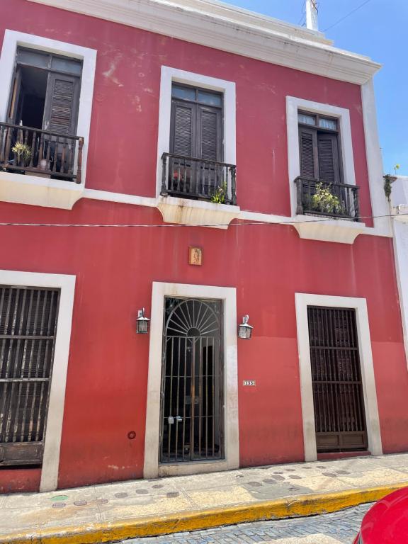 een rood gebouw op een straat met ramen bij 3-BR in the heart of the Historical City in San Juan