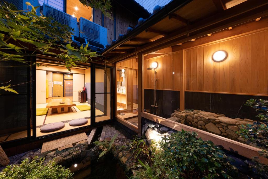 vistas al exterior de una casa con jardín y arroyo en 京恋 黄金屋 en Kyoto