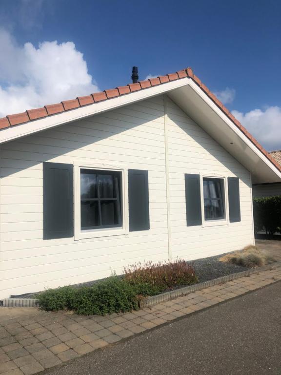 a white house with two windows and a roof at Vakantiepark Krabbenkreek in Sint Annaland