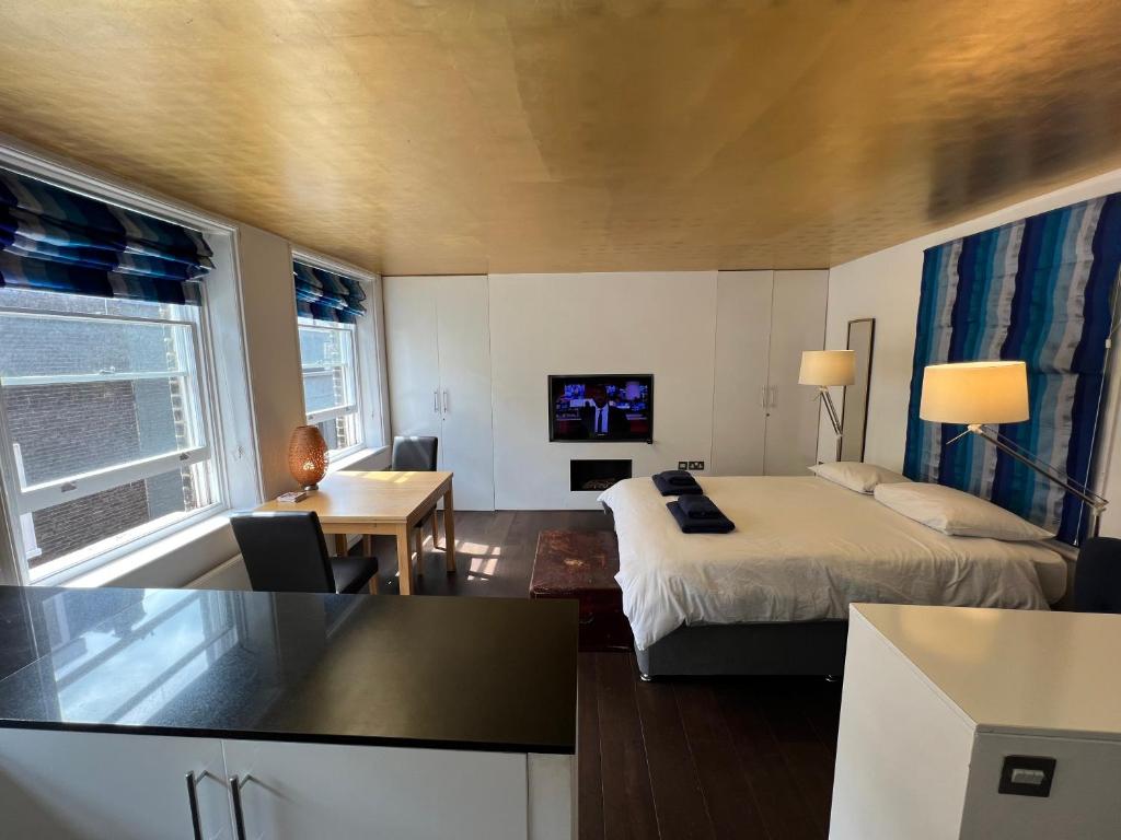 a hotel room with a bed and a tv at Studio Apartment, Covent Garden in London