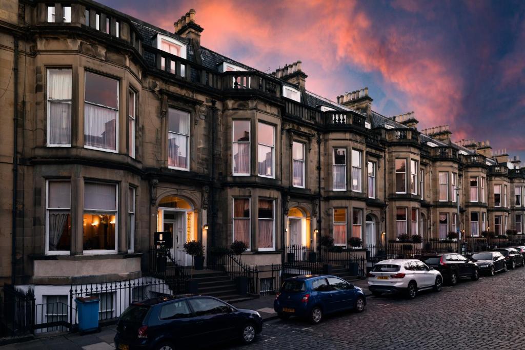 uma fila de casas com carros estacionados à frente deles em The Haymarket Hotel em Edimburgo