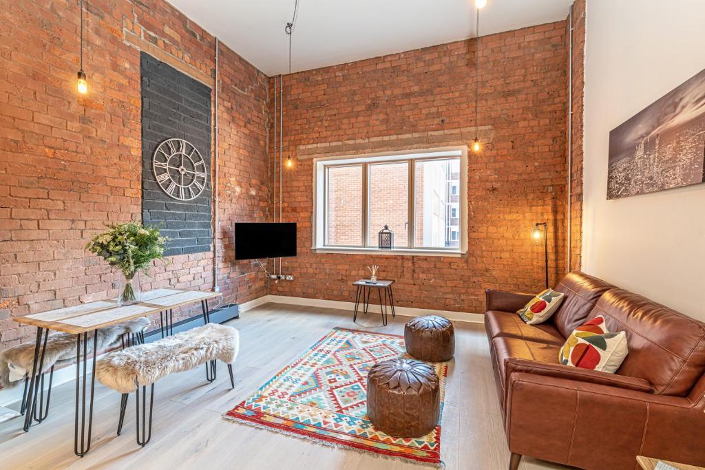 a living room with a brick wall at Carriage Works Apartments in Preston in Preston