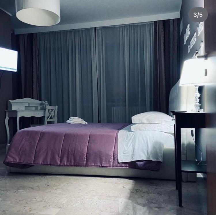 a bedroom with a bed and a table and a lamp at B&B incentro in Foggia