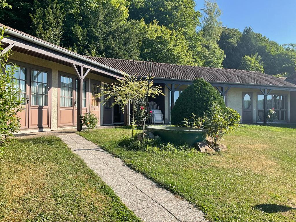 a house with a large yard next to a building at A l oree du bois in Futeau