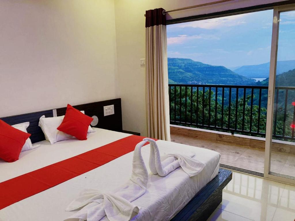 a bedroom with a bed and a large window at Kalasita in Mahabaleshwar