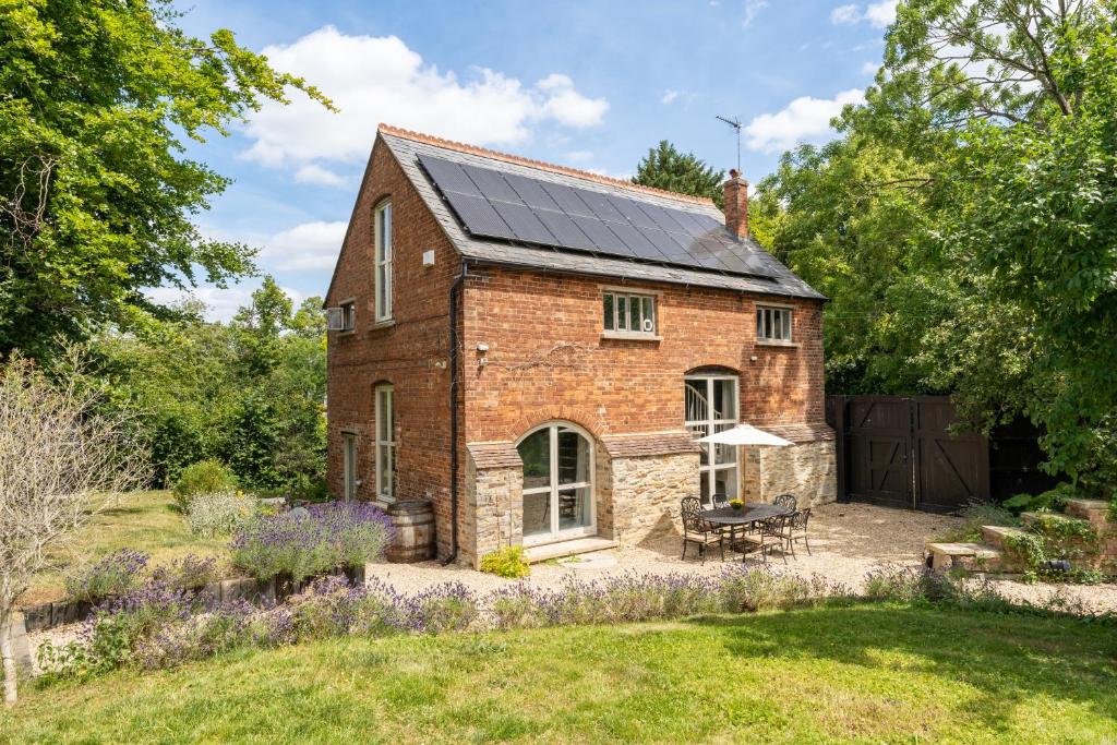 a brick house with solar panels on the roof at Stunning Victorian Converted Mill, 3 BDR Retreat in Cheltenham