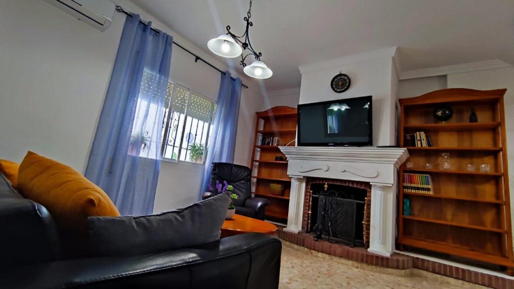 een woonkamer met een open haard en een televisie bij Apartamento completo Alhaurín de la Torre in Alhaurín de la Torre