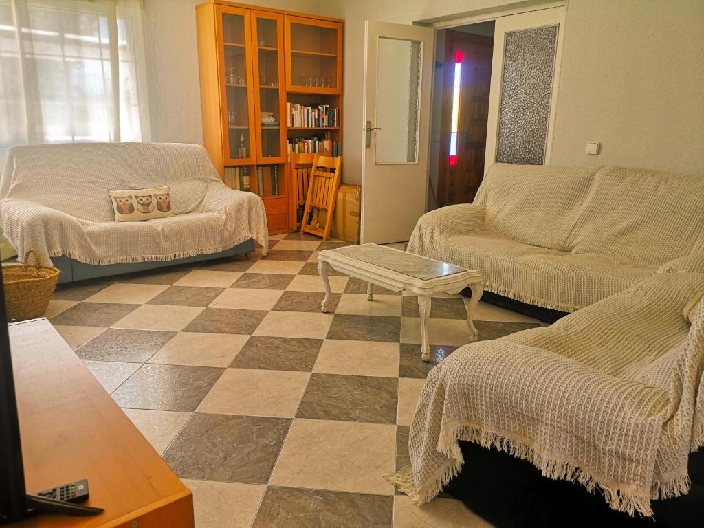 a living room with a couch and a table at Agradable casa con jardín: Casasola in San Cristóbal de Segovia