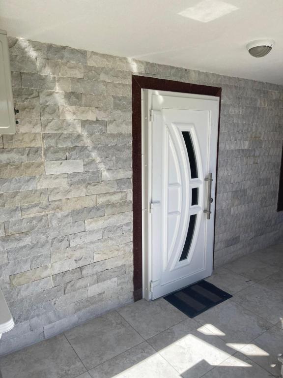 a white door in a brick wall at Νέα μεσσαγγαλα luxury suite by MAKHOME no 2 in Nea Mesangala