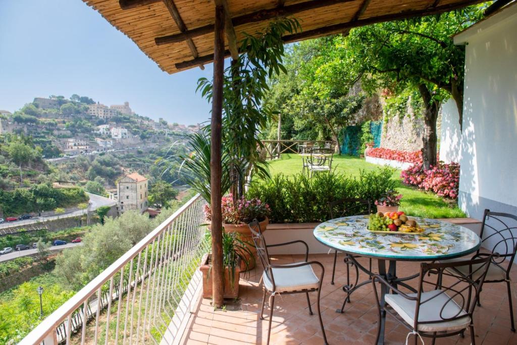 un patio con tavolo e sedie sul balcone. di IL NIDO DEGLI ANGELI a Ravello