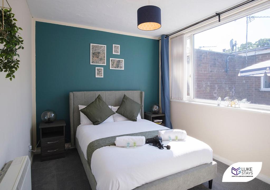 a bedroom with a bed with a blue wall at Luke Stays - Cheveley Park in Leamside