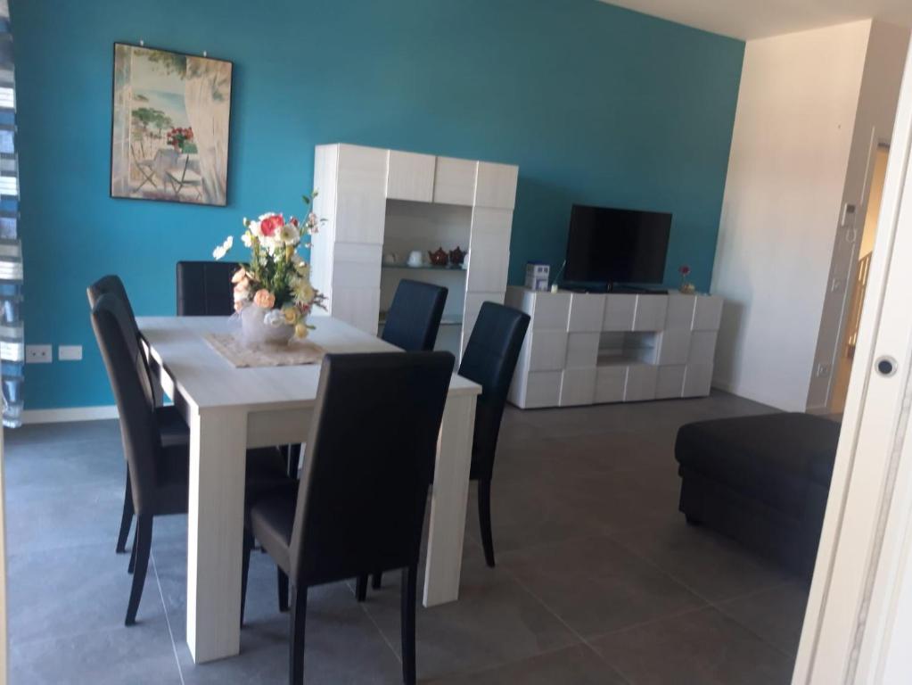 une salle à manger avec une table blanche et des chaises noires dans l'établissement Casa Mare, à Misano Adriatico