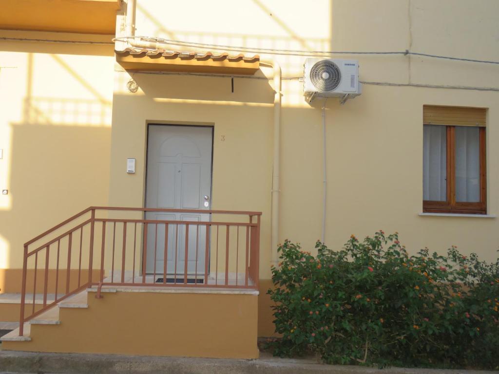 un edificio con una escalera, una puerta y una planta en Casa vacanze Aurora Tortolì en Tortolì