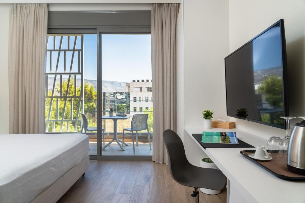 Pokój hotelowy z łóżkiem i biurkiem z biurkiem w obiekcie Athens Hill Luxury Apartments w Atenach