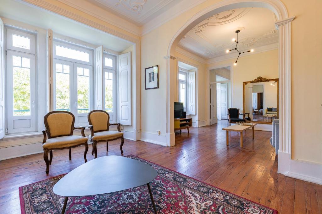 un soggiorno vuoto con sedie e tavolo di Saldanha Charming Palace a Lisbona