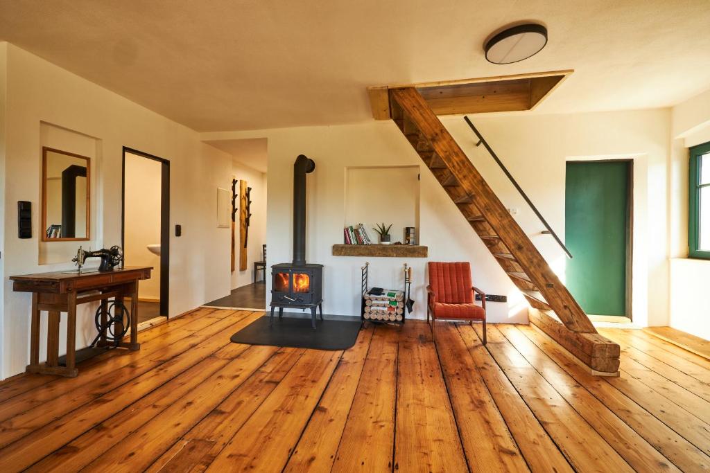 an open living room with a wood stove in the middle at Statek 85 in Mařenice