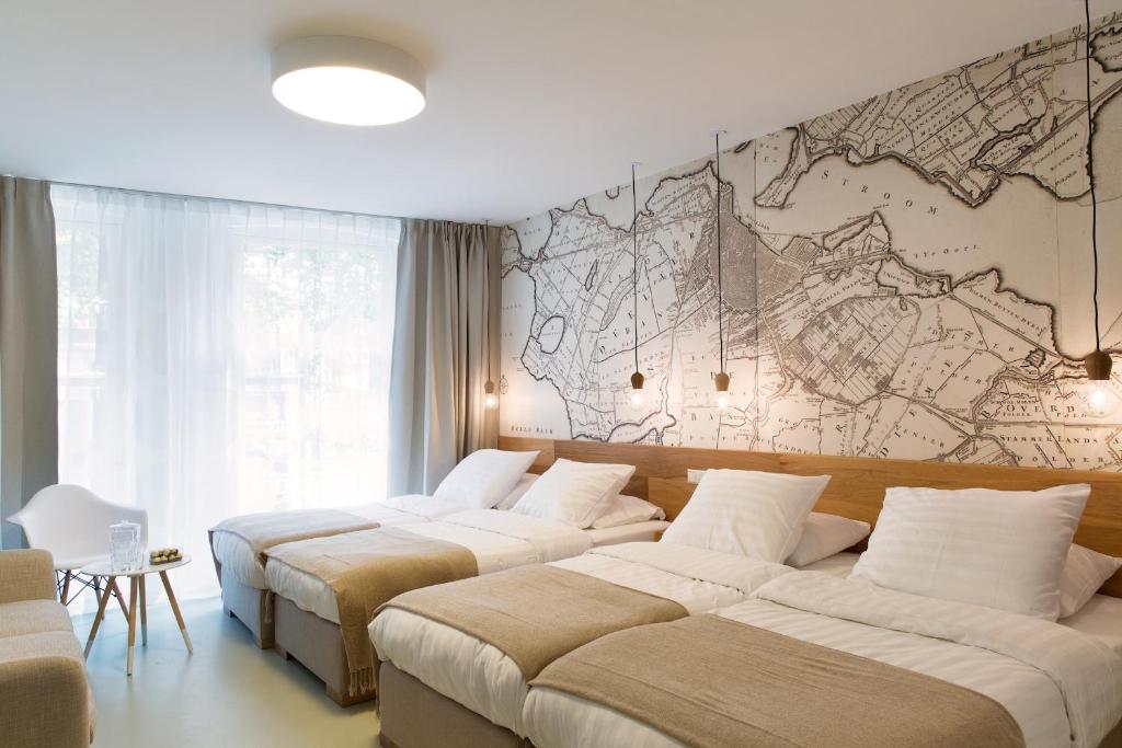 3 Betten in einem Zimmer mit einer Karte an der Wand in der Unterkunft The Mansion in Amsterdam