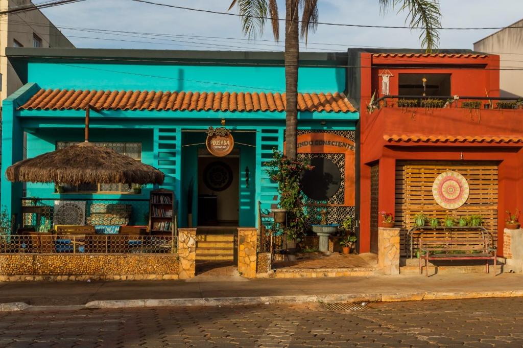 a colorful building with a bench and an umbrella at Pousada Mundo Consciente in Piauí