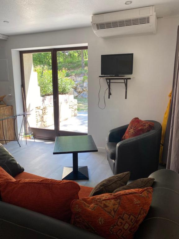 TV a/nebo společenská místnost v ubytování Hôtel Lou Caleù restaurant le Rocher des Abeilles