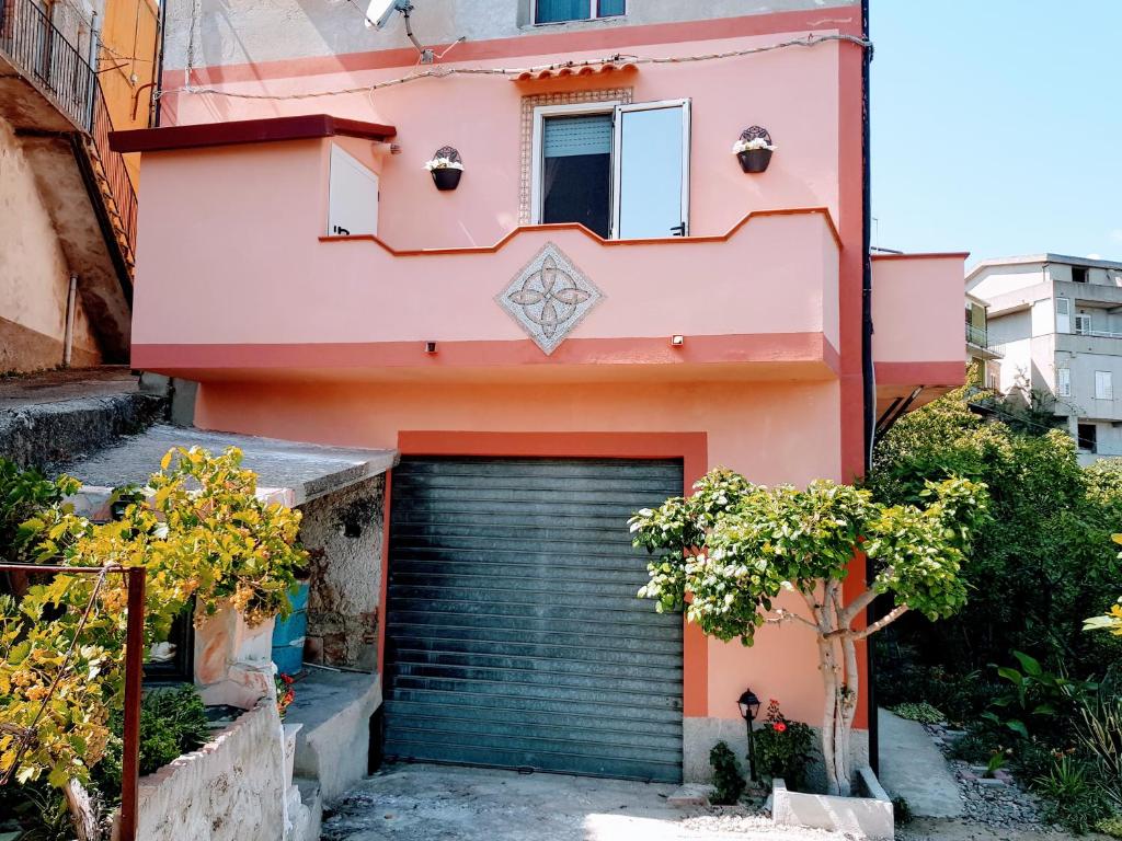 una casa rosa con un garage di fronte di A casa di Lilly ad Andali