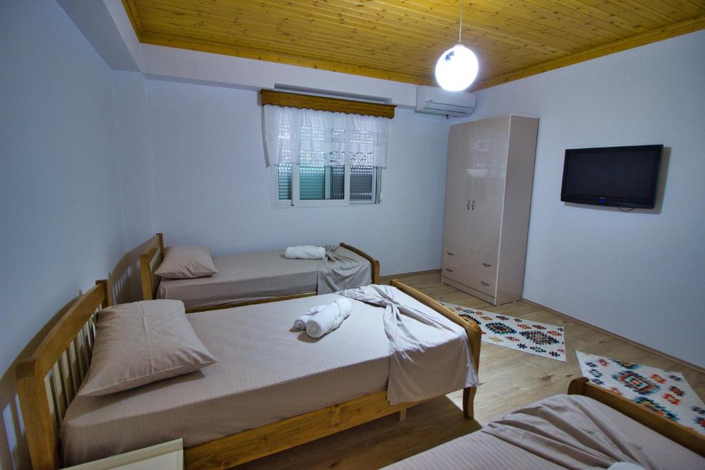 una piccola stanza con due letti e una tv di VILA SHAMETAJ a Gjirokastër