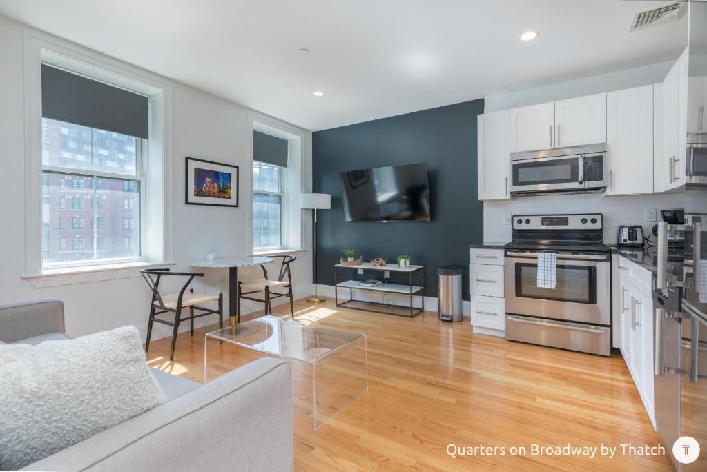 a living room with a kitchen and a dining room at West Broadway Quarters by Thatch in Boston