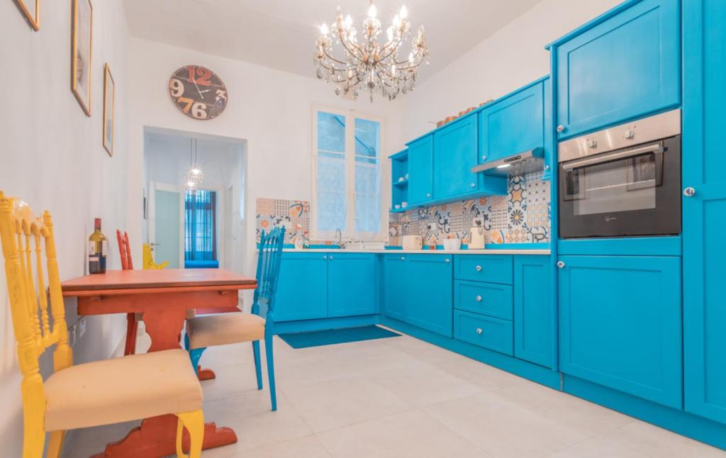 a blue kitchen with a wooden table and blue cabinets at Blue Waves Apartment with Maltese Balcony in Valletta