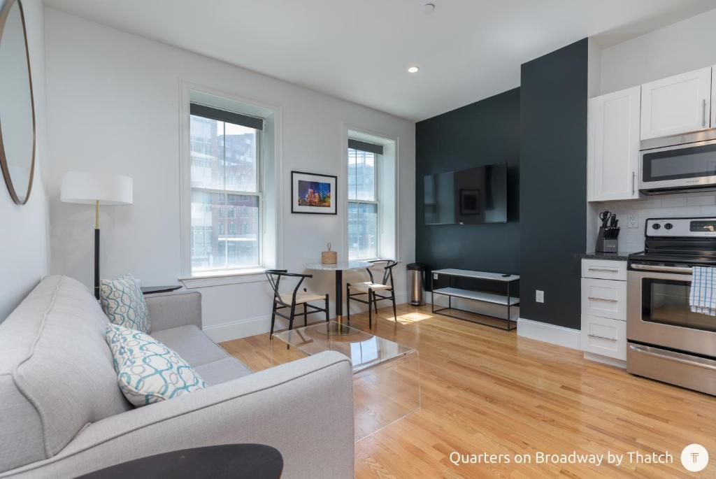a living room with a couch and a table at West Broadway Quarters by Thatch in Boston