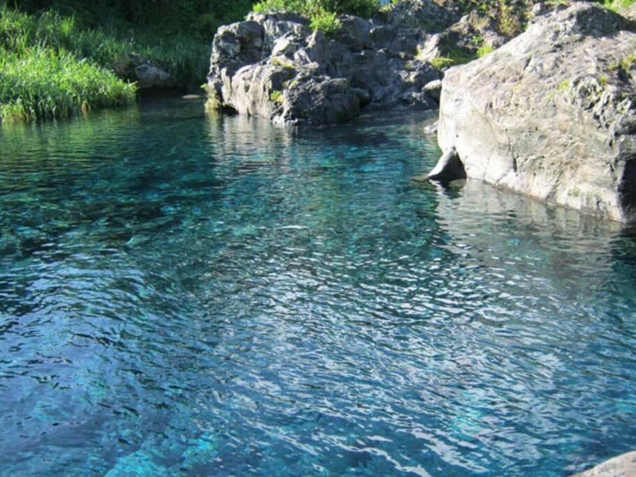 Un río con agua azul y una roca grande en kaz'manou en Saint-Benoît