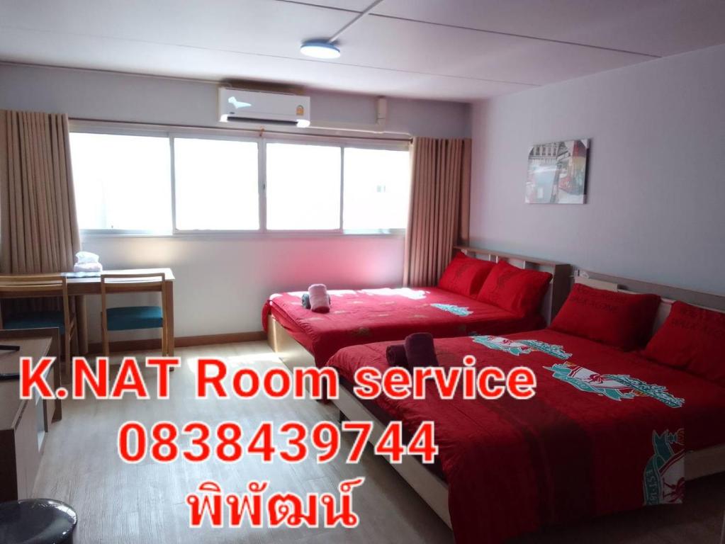 um quarto com uma cama vermelha e um sinal vermelho de serviço de quartos em K.NAT Room service em Nonthaburi