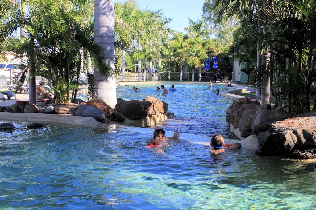 two children swimming in a pool at a resort at Big4 Aussie Outback Oasis Holiday Park in Charters Towers