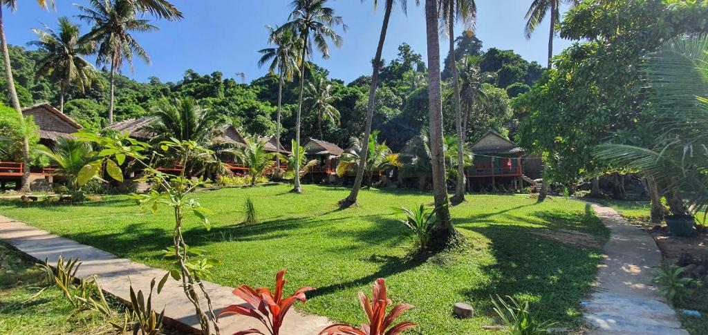 a lawn in front of a resort with palm trees at Khim Vouch Ay Rabbit island in Kep