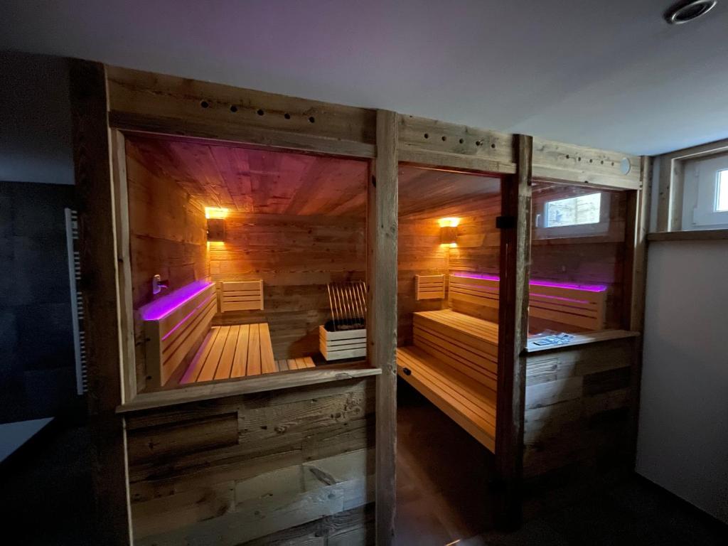 una sauna de madera con luces moradas en una habitación en Chalet Hoamat Leben, en Leogang